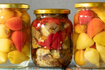 Three jars of pickled vegetables. Food conservation for autumn and winter. A close-up.