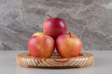 Delicious apples bundled on a platter on marble background