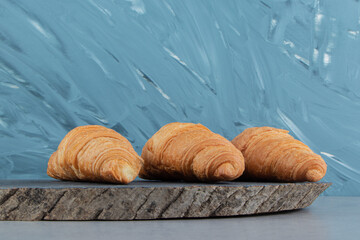 Delectable croissant on board , on the marble background