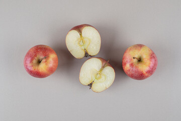 Whole and sliced apples displayed on marble background