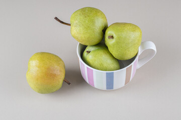 Pears in a large mug on marble background