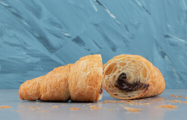 Sliced chocolate croissant on the blue background