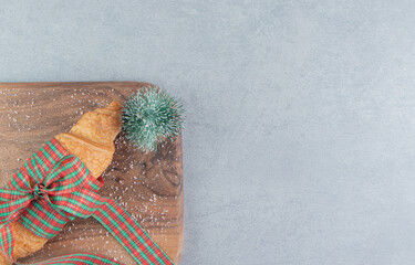 Toys and croissant on the tray, on the marble background