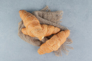 Fototapeta na wymiar Toothsome croissants on towel , on the marble background