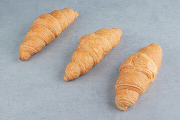 Three flavorful croissant , on the marble background
