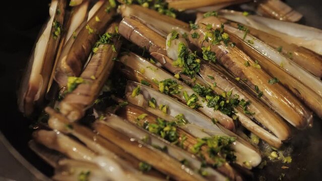 Razor clams seafood grilled on market, grill Spanish Navajas, traditional food in Spain, Catalonia, Barcelona.