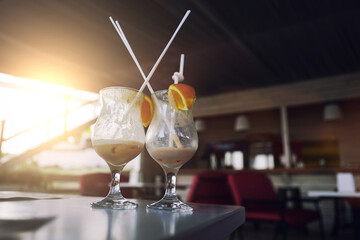 Two empty glasses with drinking straw stands on table surface in summer cafe. Party and rest concept.