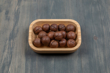 Healthy macadamia nuts in a wooden board