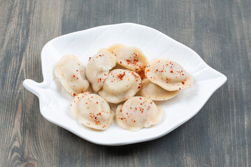 Delicious dumplings with red pepper in a white plate