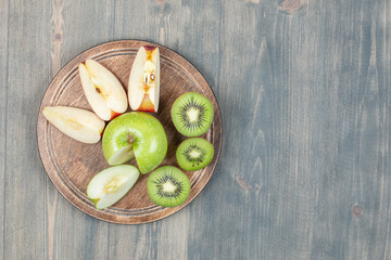 Sliced apples with fresh kiwi on a wooden table