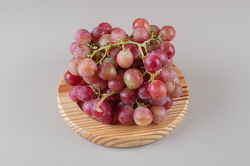 Bundle of grape clusters on a platter on marble background