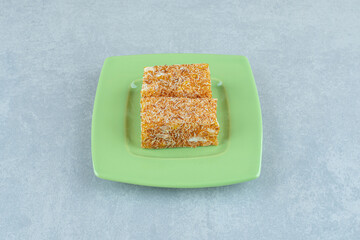 A small portion on the green plate on marble background