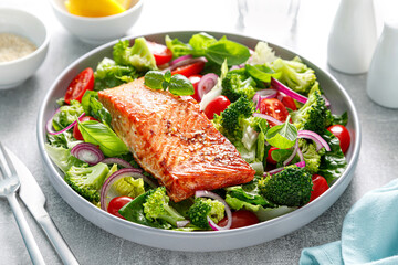 Salmon fish fillet grilled and fresh tomato salad with red onion and broccoli. Healthy food, diet. Ketogenic lunch