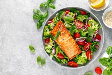  Grilled salmon fish fillet and fresh green leafy vegetable salad with tomatoes, red onion and broccoli. Healthy food. Ketogenic lunch. Top view © Sea Wave