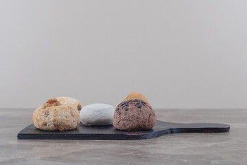 Various cookies bundled on a black board on marble background