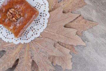 Plane tree leaves, a doily and a portion of bakhlava on marble background