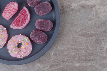 Donuts and marmelades in a small serving tray on marble background