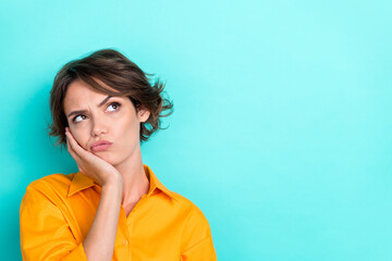 Closeup photo of young adorable gorgeous funny woman touch cheeks pouted lips unsure unsatisfied look empty space choice isolated on aquamarine color background