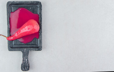 Delicious pear with pink sauce on black board
