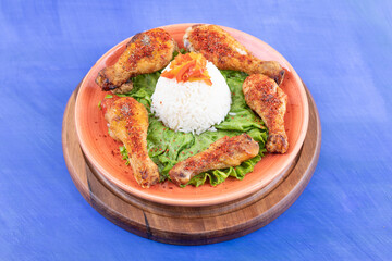A wooden board of grilled chicken legs meat with boiled egg