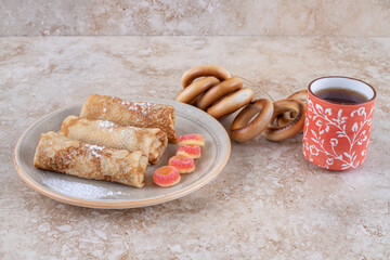 Homemade crepes with sugar powder and a cup of tea