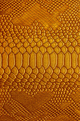 Beautiful yellow, gold bright snake or crocodile skin, reptile skin texture, multicolored close-up as a background.