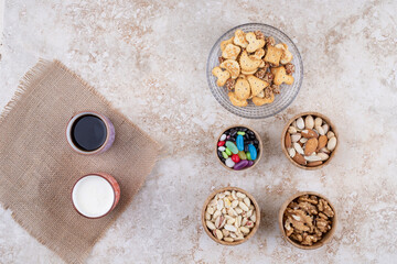 Sweets and crackers with cups of tea and nuts
