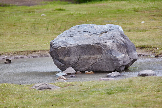 Rock in patagonian forest with blue lake and nature. Mate painting