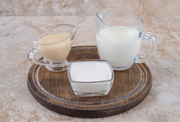 A wooden board with glass cups of milk