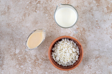 A clay bowl full of delicious cottage cheese and a glass cup of milk