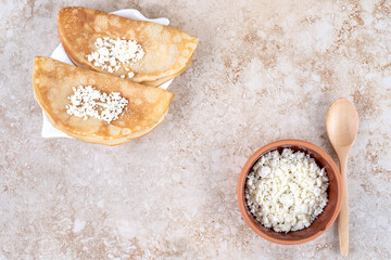 Roll pancakes with cottage cheese and a wooden spoon