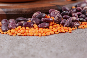 Raw kidney beans with uncooked lentils on a gray background