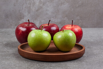 Green and red apples on wooden kitchen board