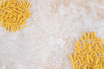 Obraz premium Two types of raw pasta on a marble background