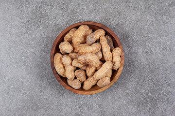 Pile of organic peanuts in wooden bowl