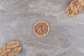 Dried lemon slice and cookies on marble background