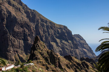 Fototapeta premium Sharp pinnacle in centre of remote tourist village Masca in the Teno mountain range, Tenerife, Canary islands, Spain, Europe. Rock formation is surrounded by steep cliffs. Gulch connceted to the sea