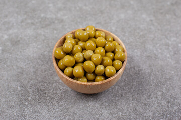 Delicious canned peas in wooden bowl