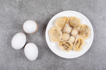 Boiled dumplings and eggs on white plate