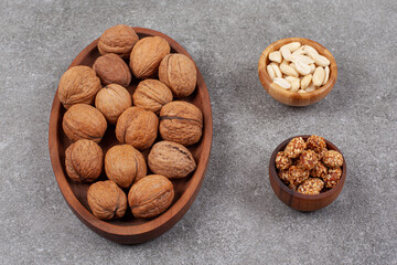 Plate of walnuts and cashew on marble surface