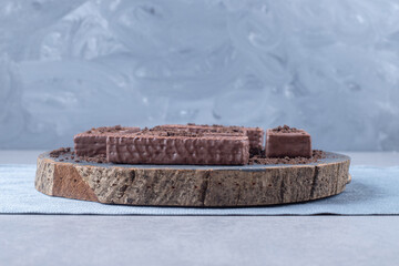 Chocolate coated wafers on a wooden boardon marble background