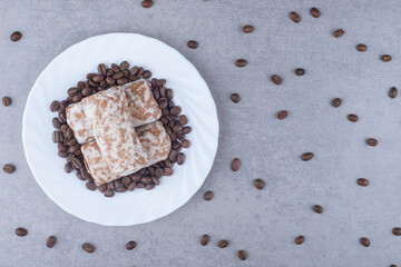Russian pryanik cookies and coffee beans on a platter on marble background