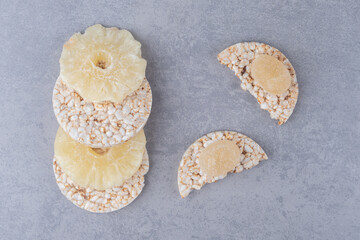 Cookies, marmelades and dried pineapple slices on marble background