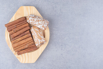 Pryanik cookies and cinnamon bundle on a small platter on marble background