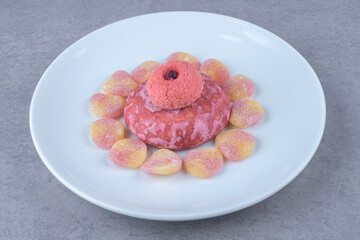 Stacked cookies surrounded with marmelades on a platter on marble background