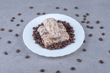 Russian pryanik cookies and coffee beans on a platter on marble background