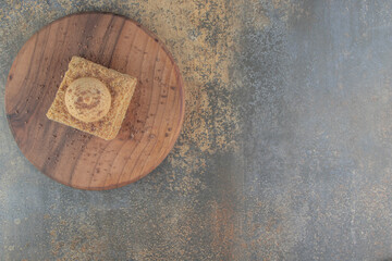 Fototapeta na wymiar Cookie on a slice of cake on a board on wooden background