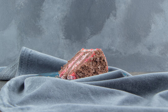 A cake slice on a platter nested on a tablecloth on marble background