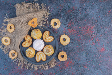 Cookies on a small platter next to dried apple slices on abstract background
