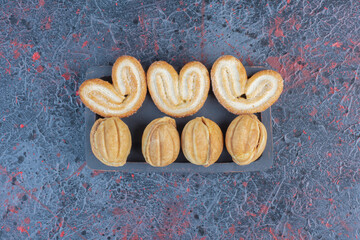 Flaky cookies and caramel filled cookie balls in a small tray on abstract background